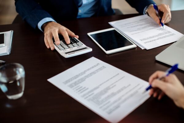 Close-up of financial consultant going through paperwork on a me